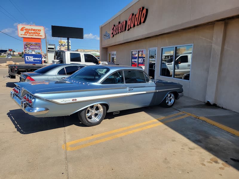 Light blue classic Impala coupe parked outside a storefront at Eastern Audio in Clovis, New Mexico