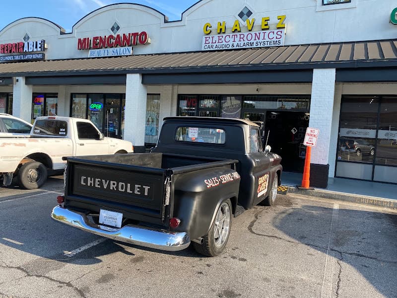 Black Chevrolet pickup truck parked outside a storefront at Chavez Electronics in Norcross, Georgia