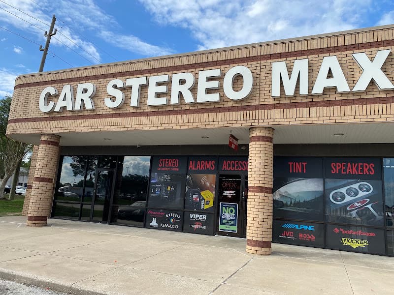 Brick storefront with stereo and alarm window signs at Car Stereo Max in Houston, Texas