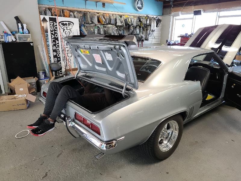 Silver classic coupe with open trunk and a person inside it at The Sound Concept in Bedford Hills, New York