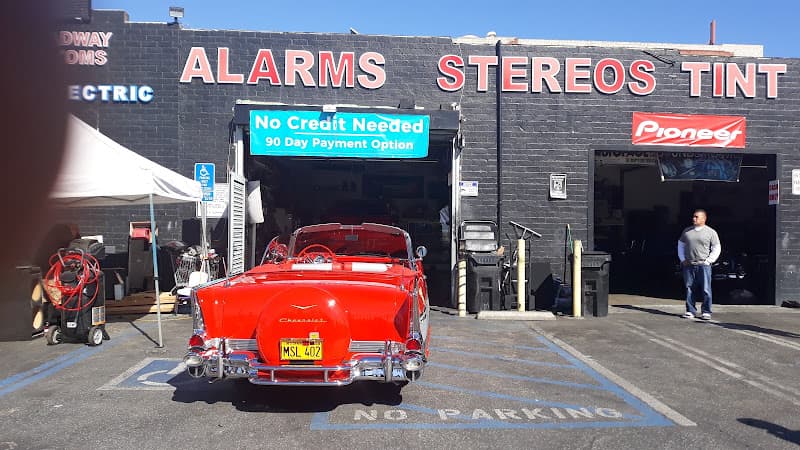 Red classic convertible parked in front of storefront at 59th Broadway Customs in Los Angeles, California