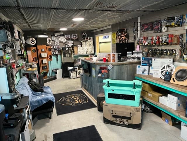Shop interior with speaker cabinets, a bar counter, and a teal cooler at Zach's Audio FX in Grove, Oklahoma