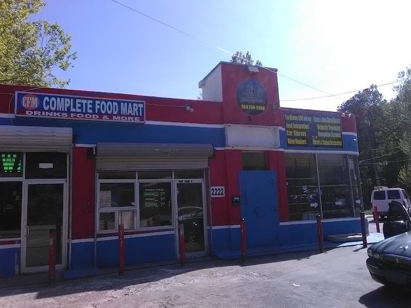 Red and blue storefront with Complete Food Mart sign at Complete Sound & Protection in Atlanta, Georgia