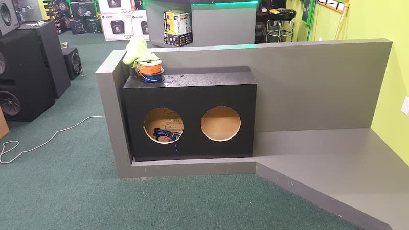 Speaker enclosure with two round cutouts on a gray platform at Crazy Car Audio in College Park, Maryland