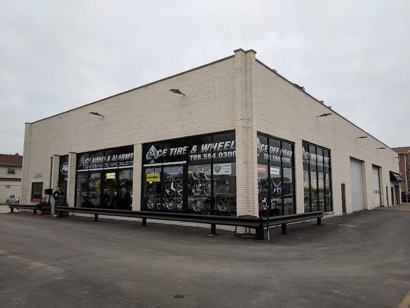 Corner of cream brick building with storefront window signs at Ace Tire & Wheel & ATW AUDIO in Bridgeview, Illinois