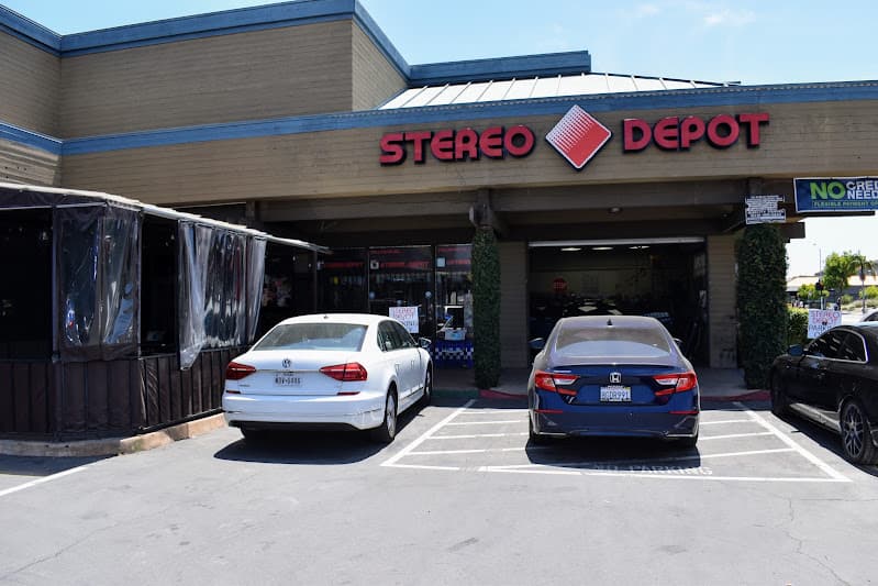 Storefront with red sign and two parked cars at Stereo Depot San Diego in San Diego, California