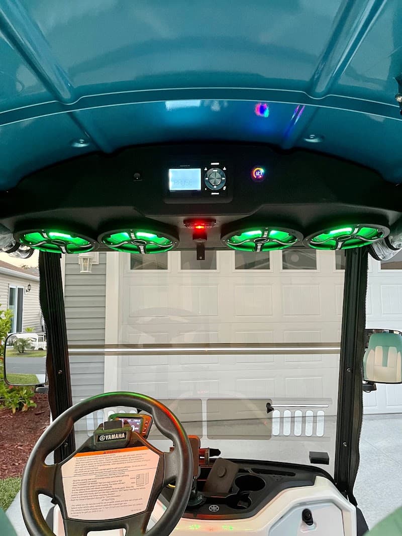 Four green-lit speakers under a teal golf cart roof at FrogHead Industries LP - Sound Systems in Beaumont, Texas