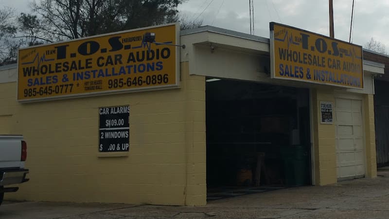 Yellow storefront with bay door and car audio signs at Tos Enterprises Car Audio & Installations in Slidell, Louisiana