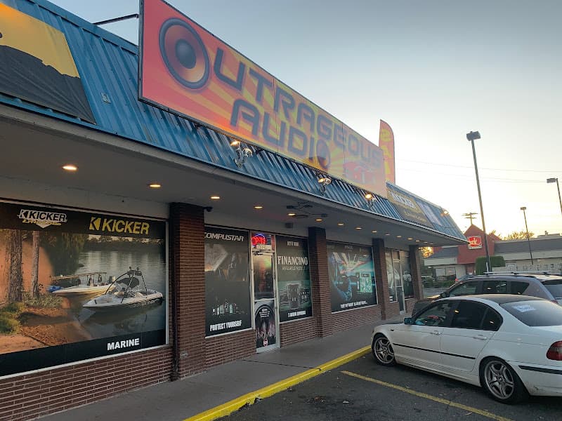 Storefront with Kicker window graphics and a large wall sign at Outrageous Audio in Portland, Oregon