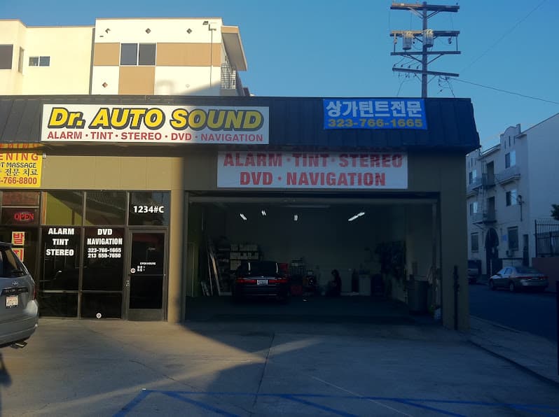 Storefront with an open garage bay and alarm, tint and stereo signs at Dr. Auto Sound in Los Angeles, California