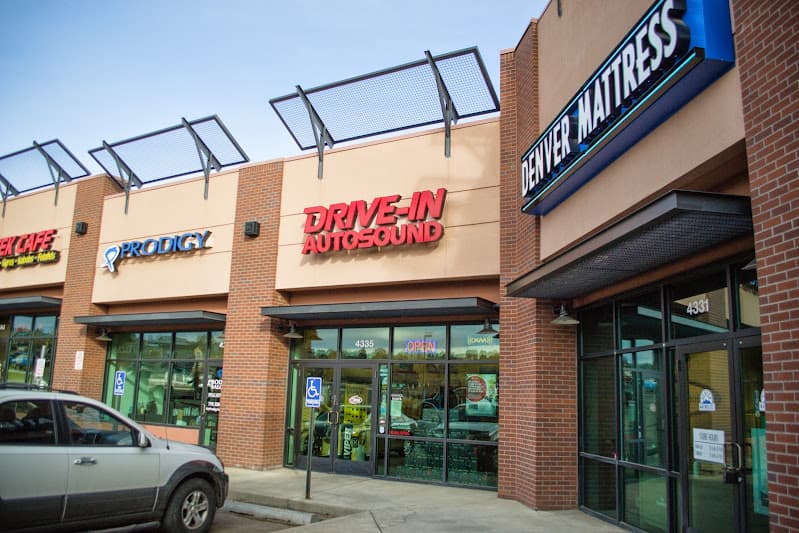Storefront with red sign and glass doors at Drive-In Autosound & Window Tint in Colorado Springs, Colorado