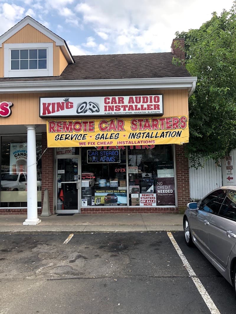 Storefront with yellow remote car starters banner and window signs at KCA King Car Audio in Norwalk, Connecticut