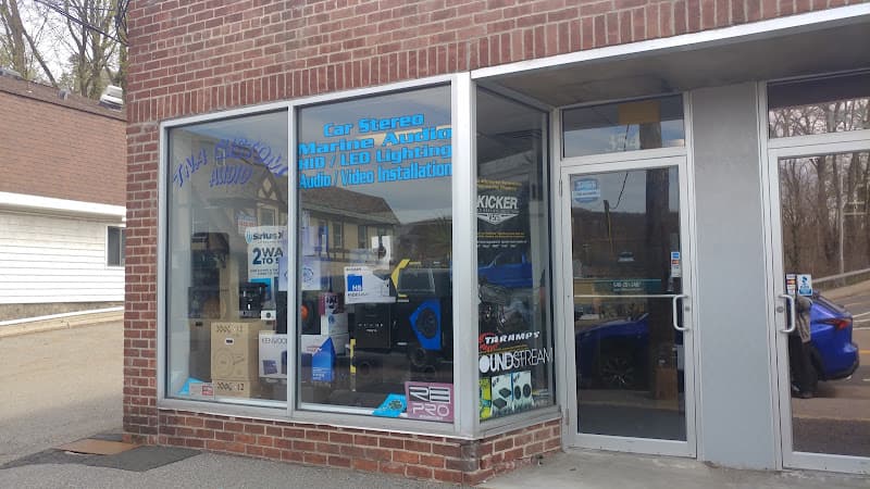 Brick storefront window with car stereo and lighting signs at TNADISCOUNTS in Hawthorne, New York