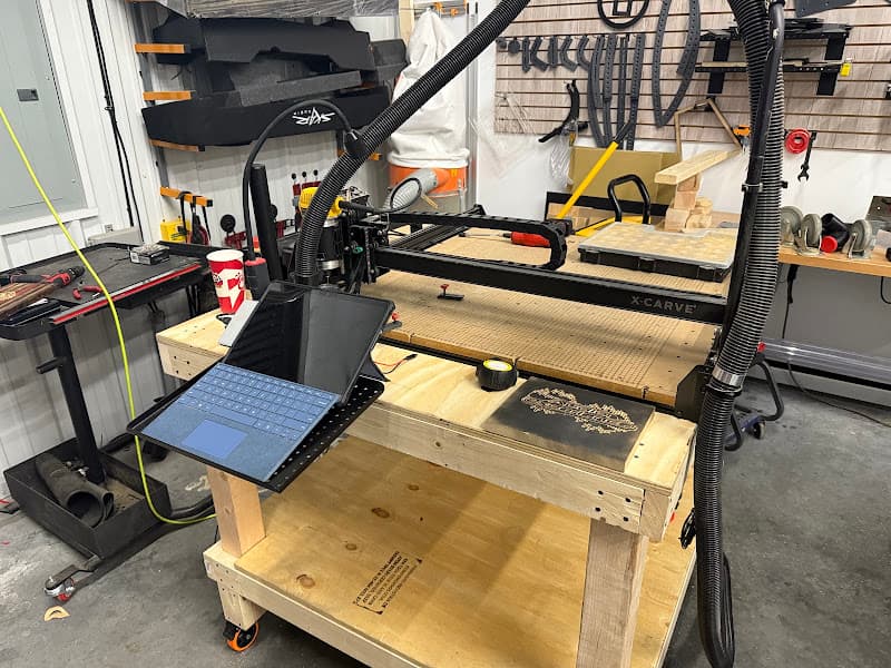 X-Carve CNC router on a wooden table next to a laptop at Audio Experience in Tulsa, Oklahoma