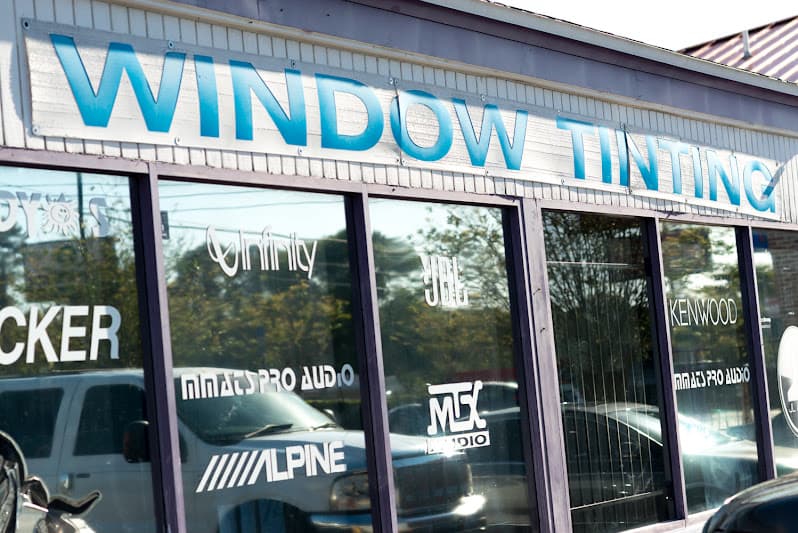 Storefront with window tinting sign and brand decals on glass at Daddyo's Discount Stereo Inc in Jacksonville, Florida
