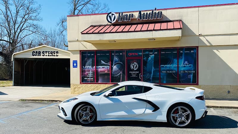 White sports car parked beside a shop with a Car Stereo sign at Valencia Car Audio in Cartersville, Georgia