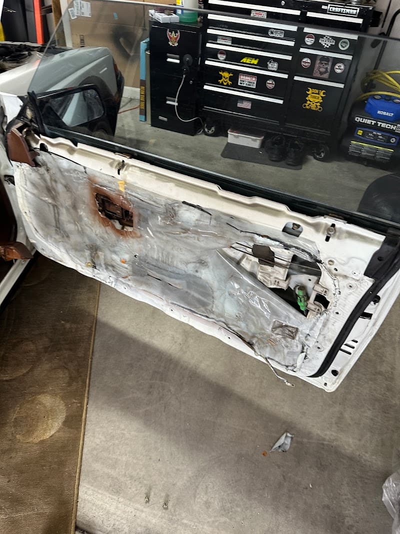 White car door with panel removed and insulation exposed at Regal Car Audio Installations in Las Vegas, Nevada