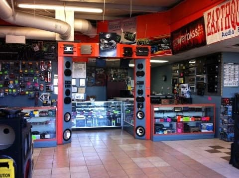 Shop interior with red walls, speaker towers and glass display cases at Infinity Car Audio in Reno, Nevada