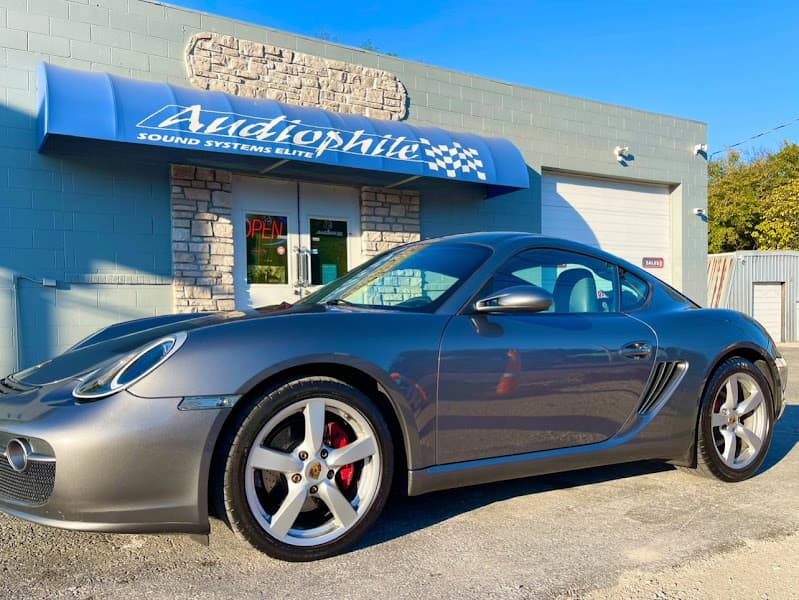 Gray sports coupe parked outside a shop with a blue awning at Audiophile Customs in Springfield, Missouri
