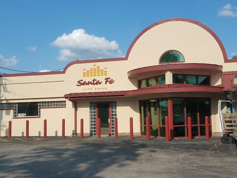 Storefront with arched roof, red bollards and logo sign at Santa Fe Auto Sound in Overland Park, Kansas