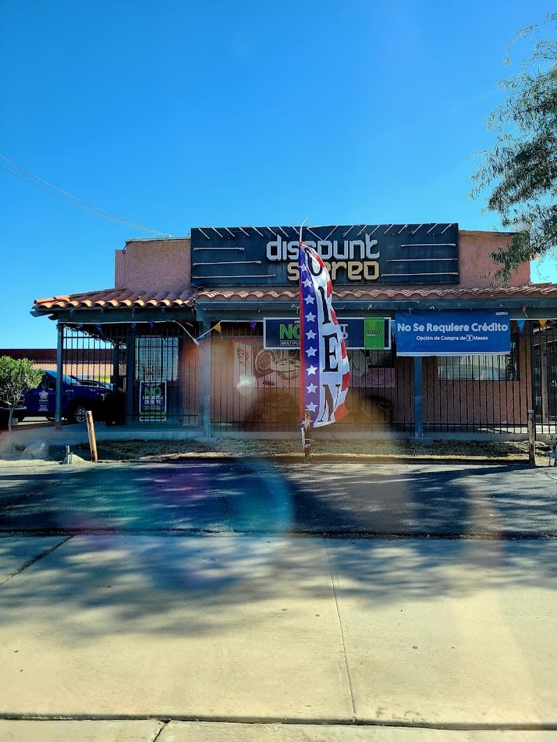 Storefront with dark sign, tiled roof and open flag at Discount Stereo in El Centro, California