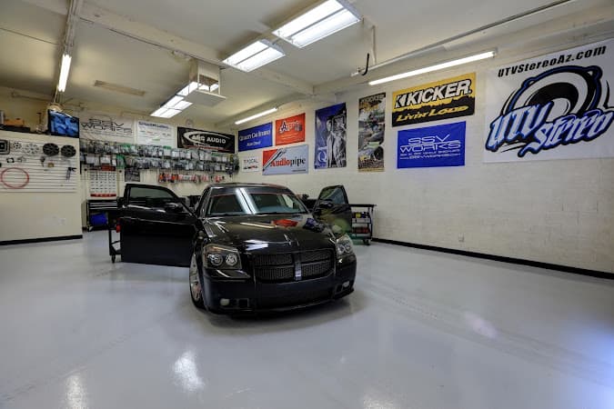 Black sedan with open doors inside a garage with audio banners at Quality Car Stereo in Mesa, Arizona