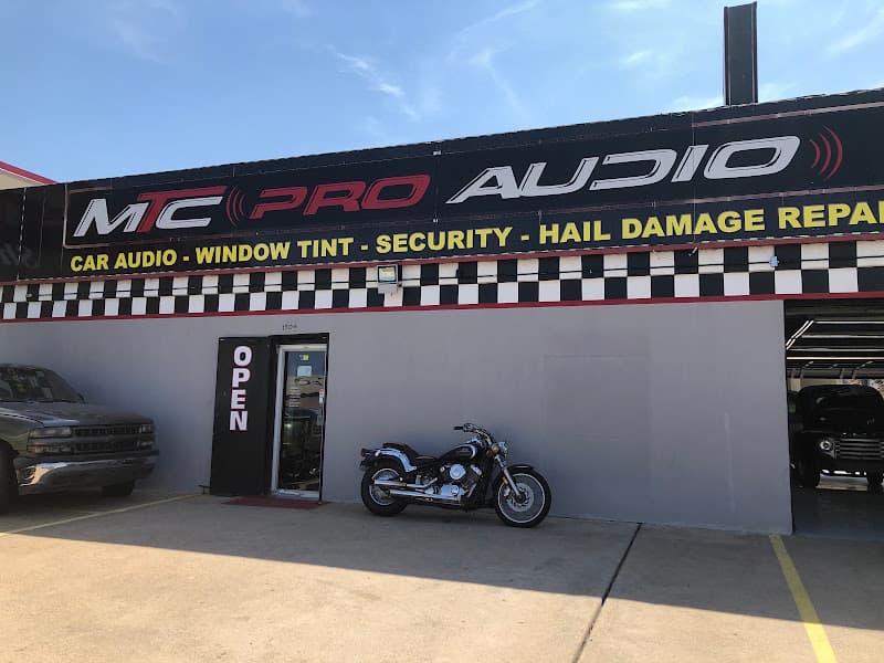 Storefront with banner sign and parked motorcycle at MTC PRO AUDIO in Plano, Texas