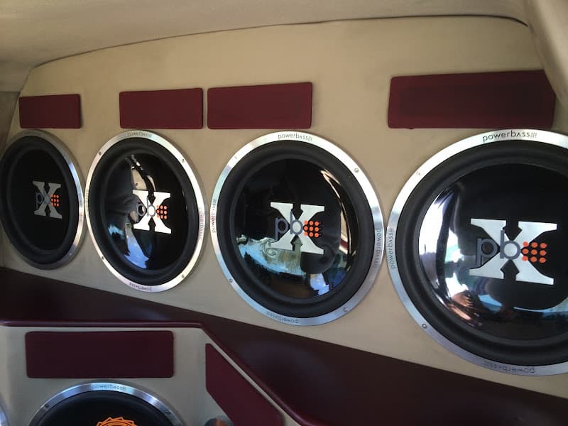 Four Powerbass subwoofers mounted in a row on a beige panel at 360 Customs in Baton Rouge, Louisiana