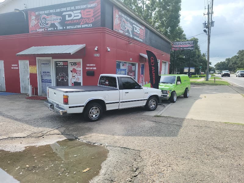 Red storefront with DS18 signs and a white pickup outside at Tweet shop in Mobile, Alabama