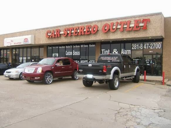 Storefront with red sign and vehicles parked out front at Car Stereo Outlet in Houston, Texas