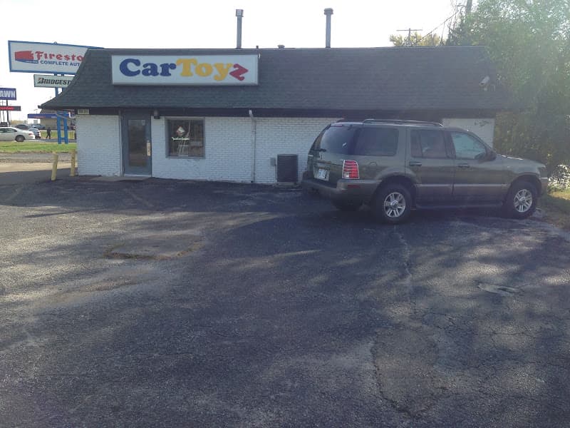 Single-story brick storefront with green SUV parked outside at Car Toyz in Raytown, Missouri