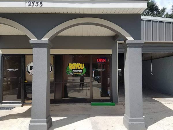 Storefront with green Bayou logo sign and arched entrance at Bayou Autosound & Security in Slidell, Louisiana