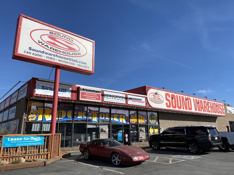 Storefront with Sound Warehouse signs and a parked red sports car at Sound Warehouse in South Salt Lake, Utah