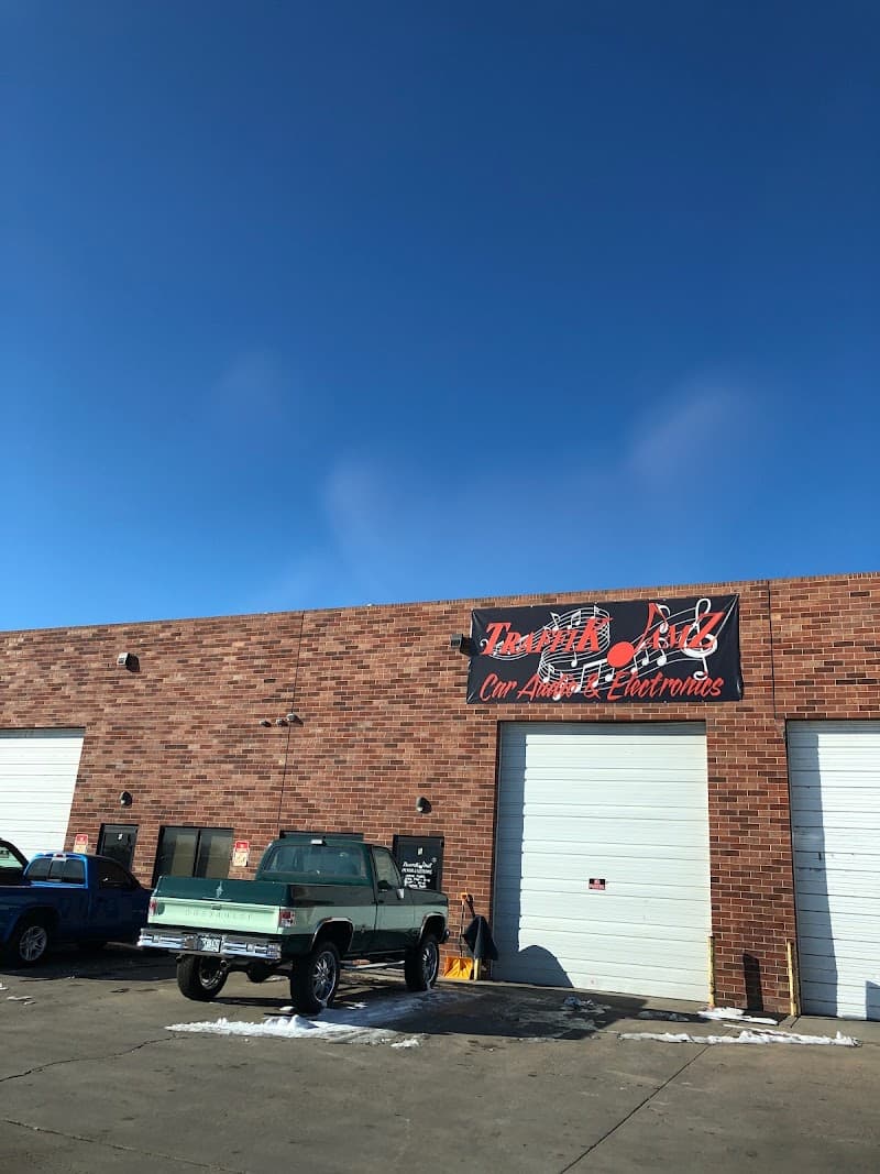 Brick building with a banner and roll-up garage doors at Traffik Jamz Car Audio in Denver, Colorado