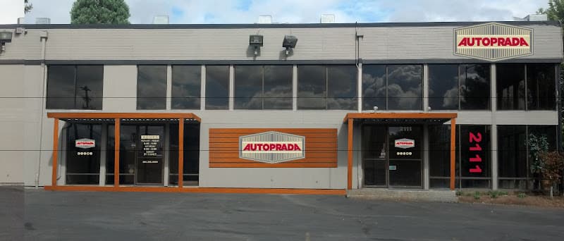 Storefront with orange trim and an AutoPrada sign at AutoPrada - Mobile West in Portland, Oregon