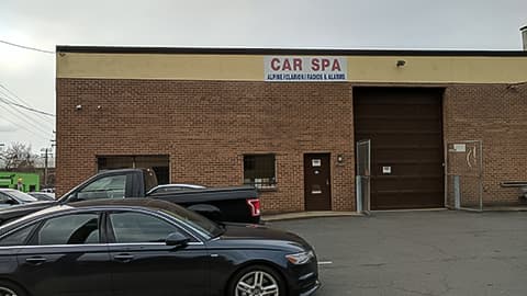 Brick building with a sign and cars at Car Spa Auto Electronics, CarPlay, Blindspot, Parking Sensors in Arlington, Virginia