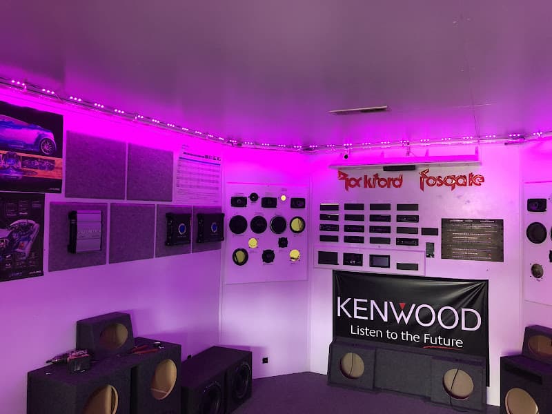 Purple-lit demo room with a Kenwood banner and speaker enclosures at Custom Car Stereo in Owensboro, Kentucky