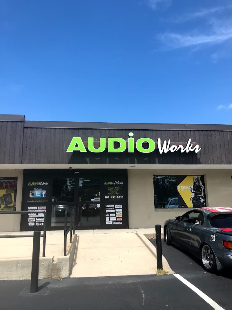 Storefront with lime green sign and black glass entry doors at Audio Works in Newark, Delaware