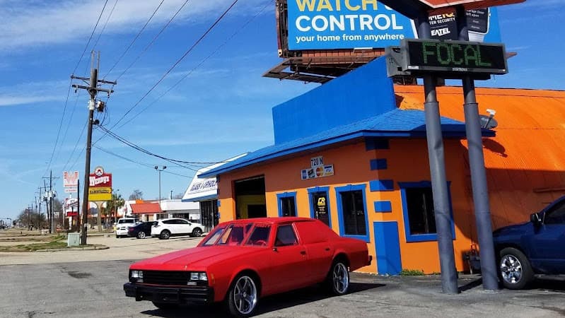 Red sedan parked outside orange and blue shop with Focal sign at Crazy Ralph's Car Stereo in Gonzales, Louisiana