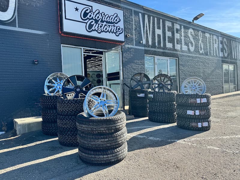 Storefront with stacked tires and alloy wheels out front at Colorado Customs Wheels and Tires in Denver, Colorado