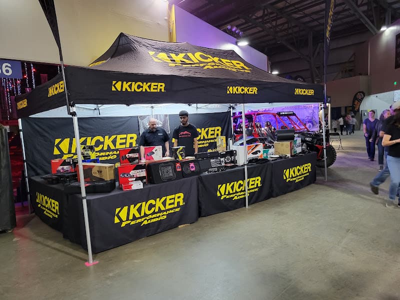 Kicker booth with two staff and speakers on a display table at 12volt mobile in Denver, Colorado