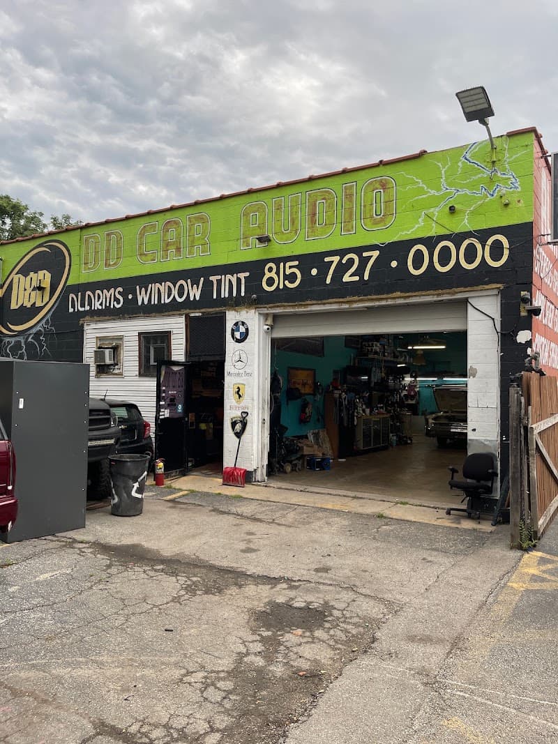 Lime green storefront with open garage door and window tint sign at D D Car Audio in Lockport, Illinois