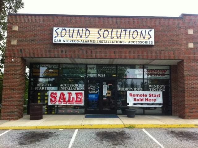 Brick storefront with red Sale sign in window at Sound Solutions in Greensboro, North Carolina