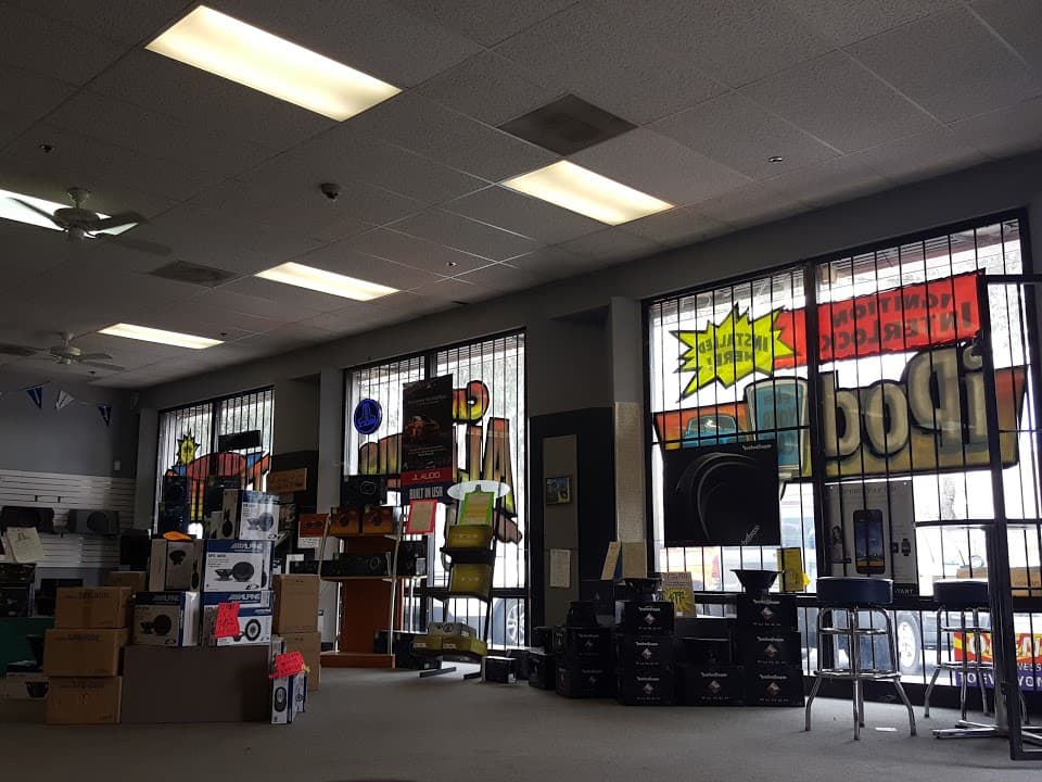 Showroom with stacked speaker boxes and a store window sign at Sounds Good To Me in Tempe, Arizona