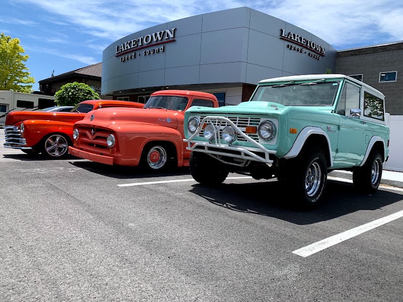 Three vintage vehicles parked in front of a building at Laketown Speed and Sound in Draper, Utah