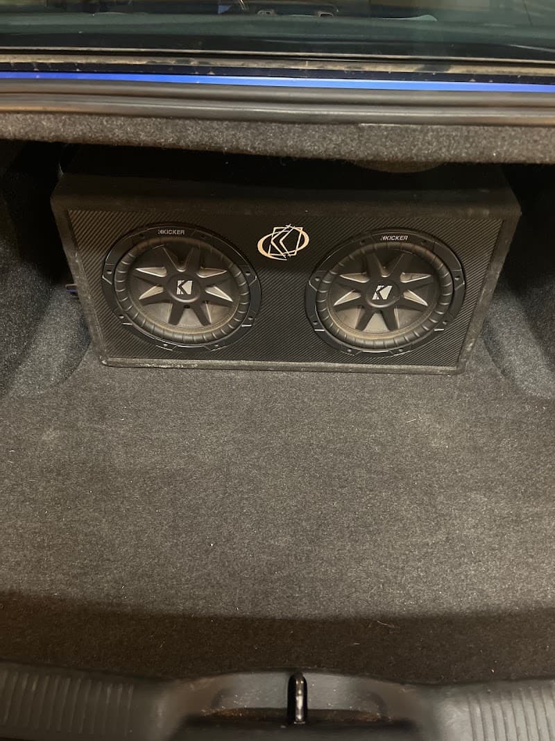 Two Kicker subwoofers in a black box in a car trunk at SOCO AUDIO AND CUSTOM WORKS in Colorado Springs, Colorado