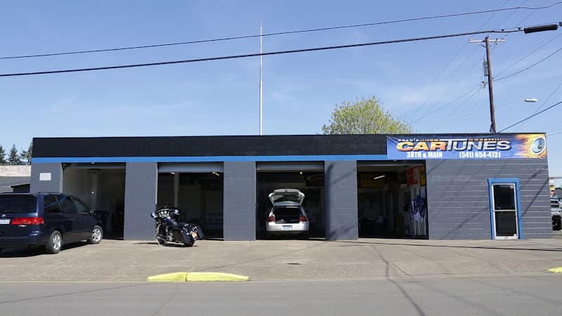 Gray block building with open service bays and a minivan outside at Brad's Car Tunes #2 in Springfield, Oregon