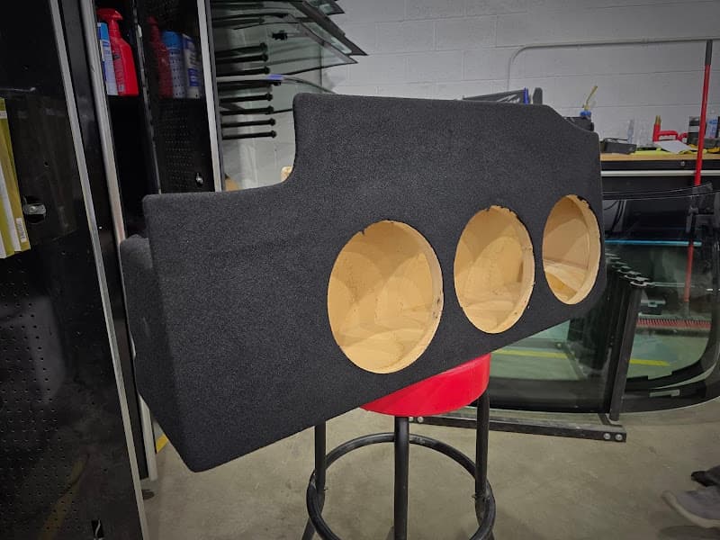 Black carpeted subwoofer box with three round cutouts at 406 Custom Auto & Sound in Havre, Montana