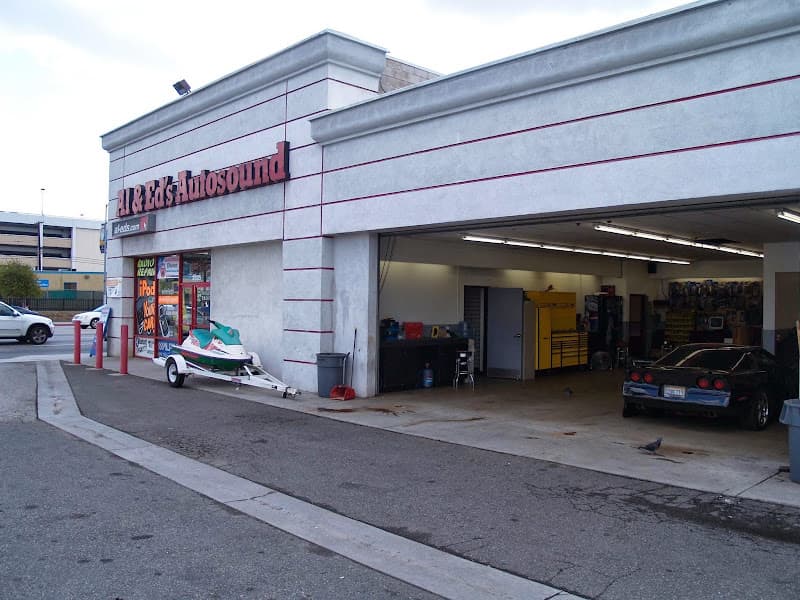 Storefront with red sign, boat trailer, and car in service bay at Al & Ed's Autosound in Los Angeles, California