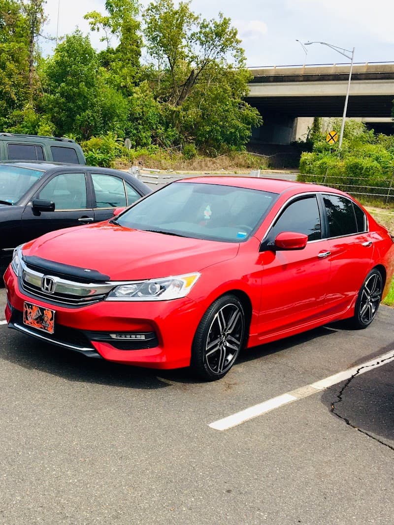 Red Honda sedan parked in a lot near an overpass at B & C Installations Inc in Watertown, Connecticut